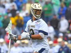 Josh Yago, da Notre Dame, faz a saudação do Memorial Day durante o hino antes do jogo do campeonato de lacrosse
