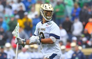 Josh Yago, da Notre Dame, faz a saudação do Memorial Day durante o hino antes do jogo do campeonato de lacrosse