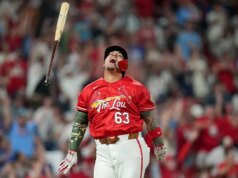 Torcedores sem camisa do Cardinals ocupam seção vazia em cena elétrica durante a vitória sobre o Royals