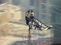 Duas pessoas sobem ao topo do Empire State Constructing com uma enorme faixa